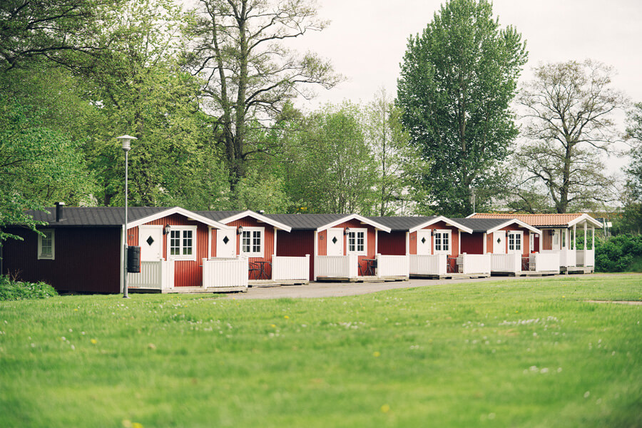 Rad med röda och vita campingstugor