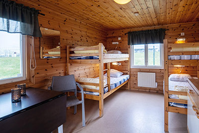 Stuginteriör med våningssängar och bord